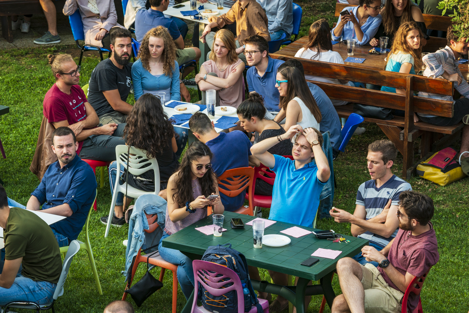 Gruppi di ragazzi che parlano seduti nel giardino del campus renati